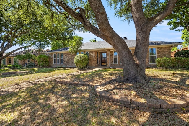 ranch-style house featuring brick siding and a front yard