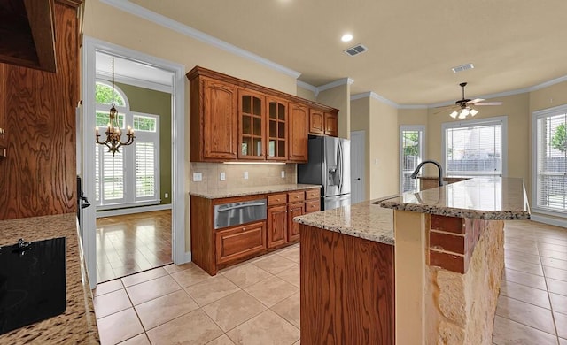 1105 Charing Cross Dr, Waco, TX 76712 - kitchen featuring a warming drawer, stainless steel fridge, black electric stovetop, brown cabinets, and a chandelier