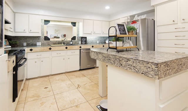 1022 Kintner Dr, Graham, TX 76450 - kitchen with a sink, stainless steel appliances, a kitchen island, decorative backsplash, and light tile patterned floors
