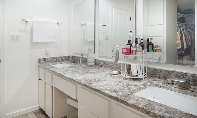 1022 Kintner Dr, Graham, TX 76450 - full bathroom with vanity, a spacious closet, baseboards, and wood finished floors