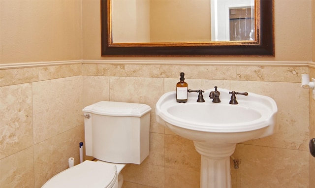 1022 Kintner Dr, Graham, TX 76450 - half bathroom featuring toilet, tile walls, and a wainscoted wall