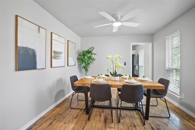 dining area featuring baseboards, hardwood / wood-style flooring, and ceiling fan