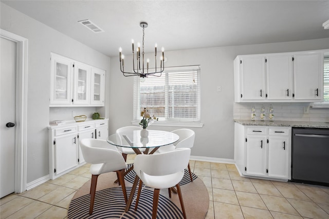 dining space featuring light tile patterned floors, a chandelier, plenty of natural light, and baseboards