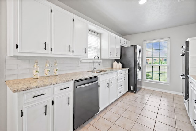 kitchen with a sink, stainless steel appliances, white cabinets, and tasteful backsplash
