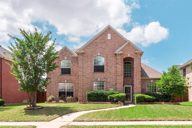 traditional-style home with brick siding and a front yard
