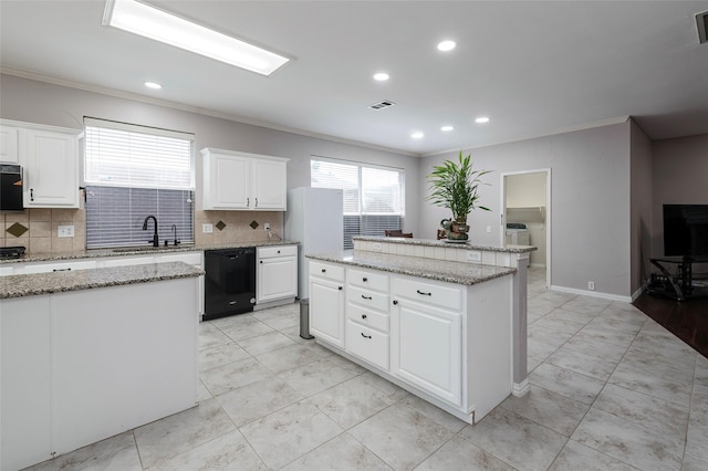 kitchen with black dishwasher, crown molding, a center island, backsplash, and a sink
