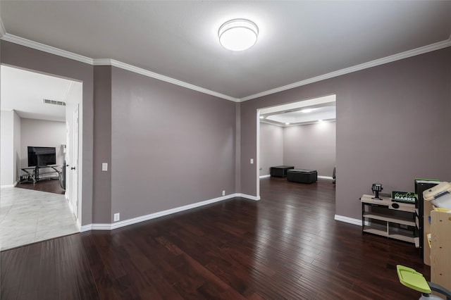 unfurnished room with baseboards, crown molding, and wood finished floors