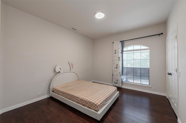 bedroom featuring baseboards and wood finished floors