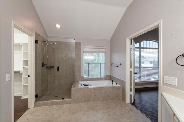 full bathroom with a shower stall, vaulted ceiling, a garden tub, tile patterned floors, and a walk in closet