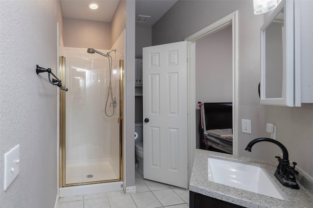 full bath featuring a stall shower, tile patterned floors, toilet, and vanity