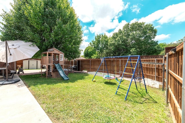 view of playground featuring a shed, an outdoor structure, and a patio