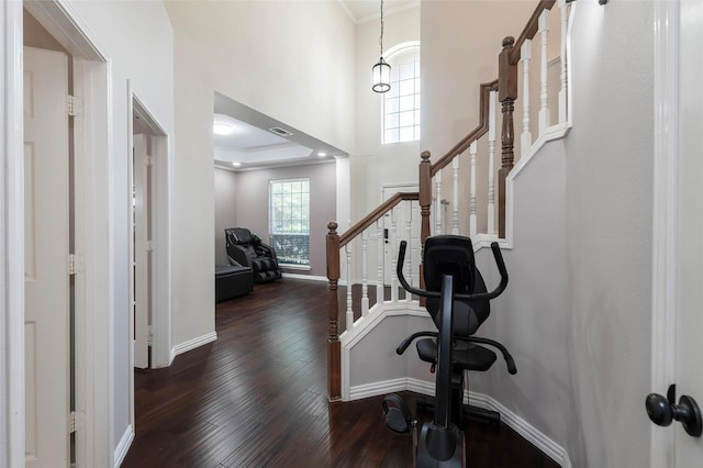 entrance foyer featuring hardwood / wood-style flooring, ornamental molding, baseboards, stairway, and a towering ceiling