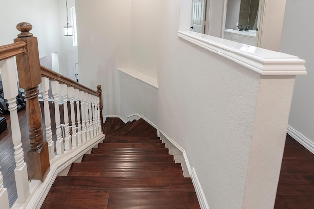 staircase featuring wood finished floors and baseboards
