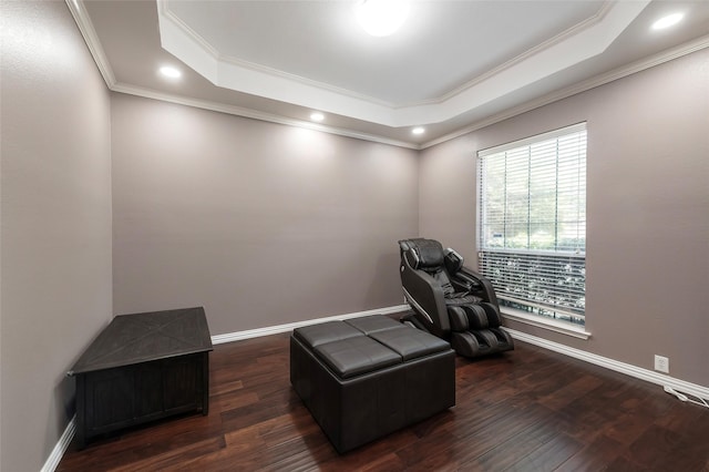 sitting room with a tray ceiling, ornamental molding, wood finished floors, recessed lighting, and baseboards