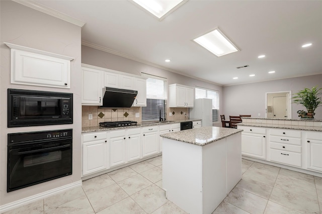 kitchen with black appliances, ornamental molding, a sink, decorative backsplash, and a kitchen island