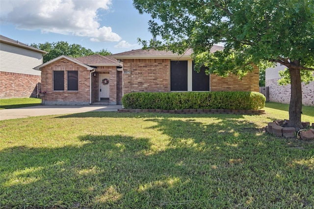 ranch-style house with brick siding, a front lawn, and roof with shingles