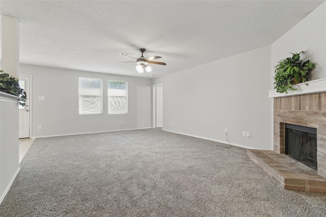 unfurnished living room featuring a ceiling fan, carpet flooring, a fireplace, a textured ceiling, and baseboards