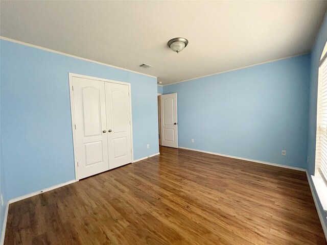 2041 Matador Ranch Rd, Fort Worth, TX 76134 - unfurnished bedroom with ornamental molding, wood finished floors, baseboards, a closet, and multiple windows