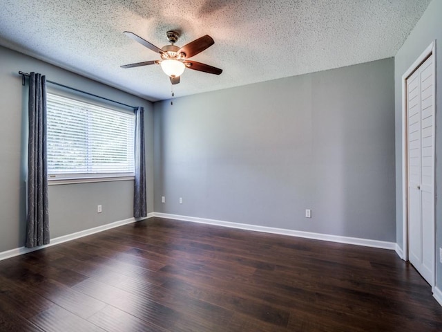 unfurnished room with ceiling fan, a textured ceiling, wood finished floors, and baseboards
