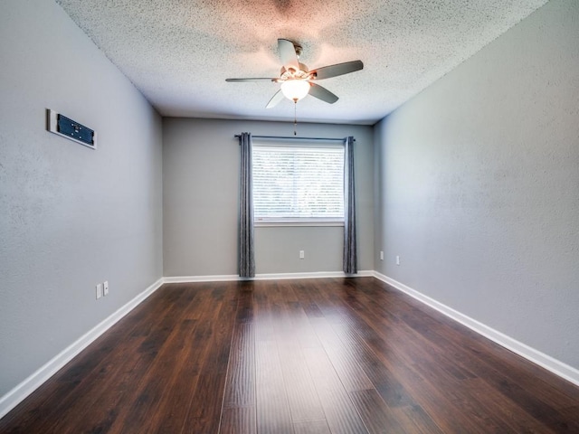 spare room with a ceiling fan, a textured ceiling, wood finished floors, baseboards, and a textured wall