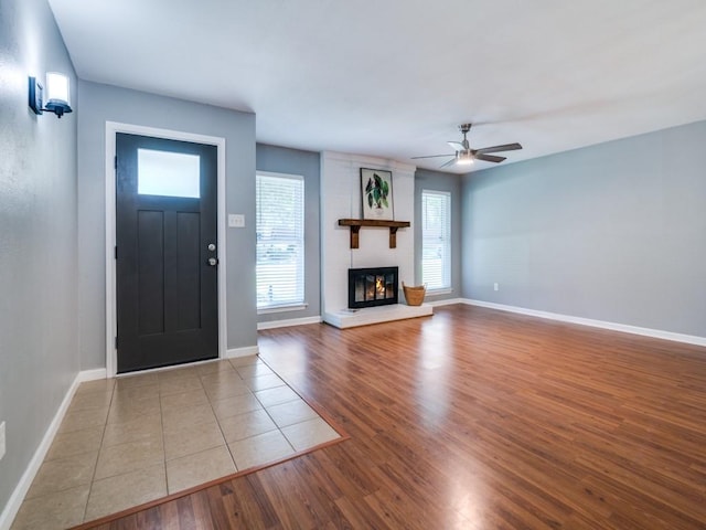 unfurnished living room featuring wood finished floors, a ceiling fan, and baseboards
