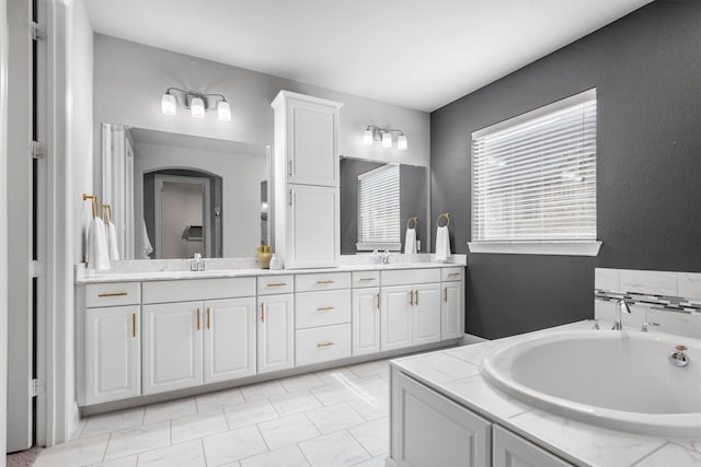 bathroom with a garden tub and double vanity