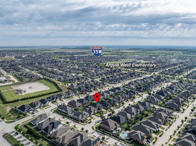 aerial view of property and surrounding area featuring nearby suburban area