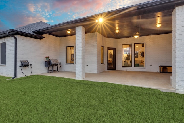 109 Highland Ranch Dr, Paradise, TX 76073 - back of property at dusk with brick siding, a patio, and a yard