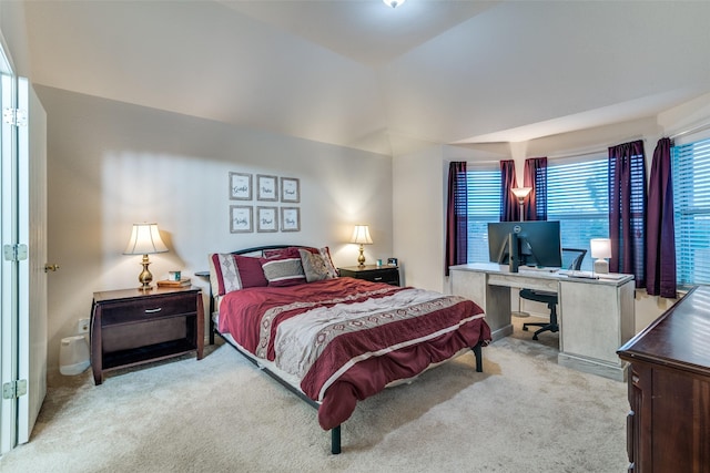 carpeted bedroom featuring an office area
