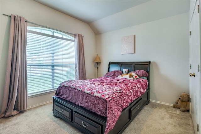 bedroom featuring light colored carpet, multiple windows, lofted ceiling, and baseboards