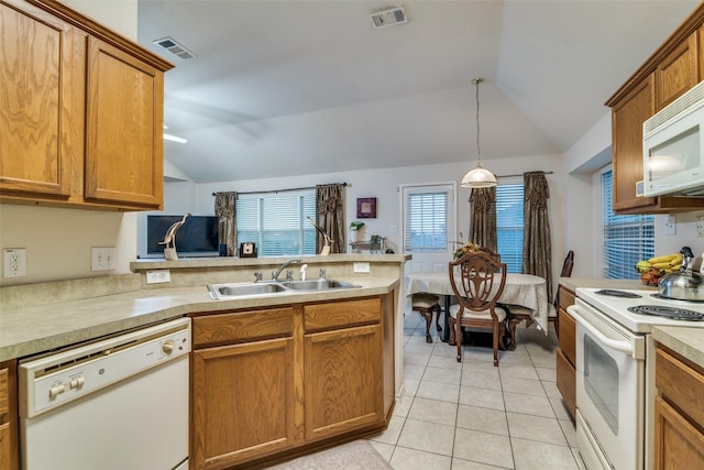 kitchen featuring white appliances, a sink, vaulted ceiling, a peninsula, and light countertops