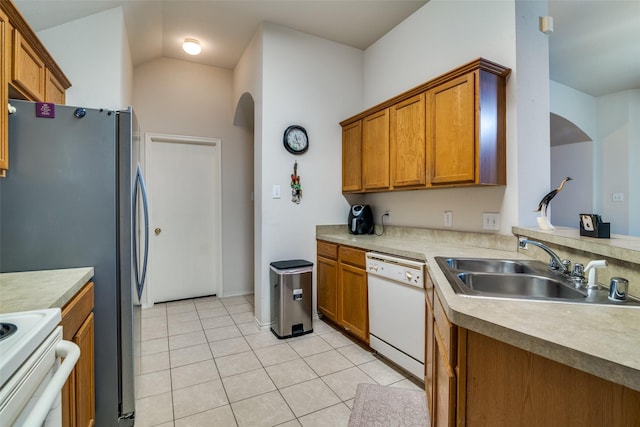14117 Golden Pass Rd, Balch Springs, TX 75181 - kitchen with dishwasher, a sink, arched walkways, brown cabinets, and light tile patterned floors