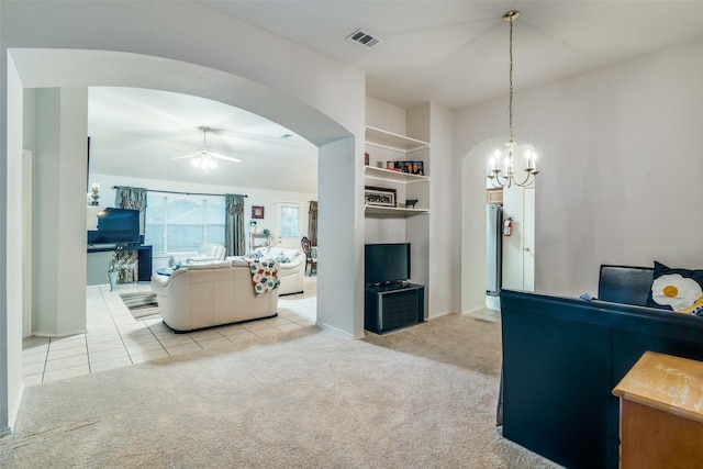 living room with ceiling fan, light carpet, arched walkways, a chandelier, and baseboards