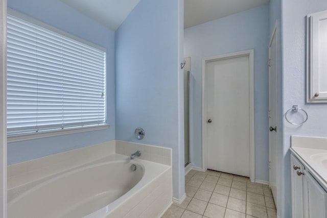 bathroom with vanity, a shower stall, a bath, tile patterned flooring, and baseboards