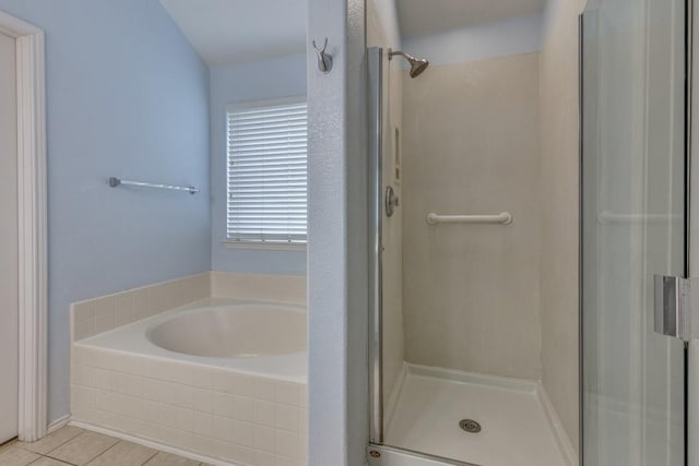 full bathroom featuring a shower stall, a bath, and tile patterned flooring