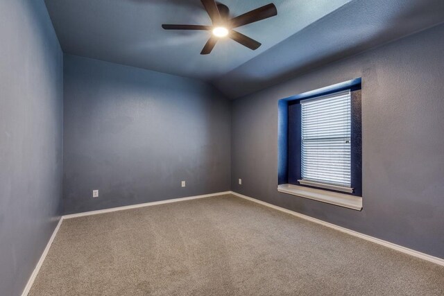 carpeted spare room featuring a ceiling fan, baseboards, and lofted ceiling