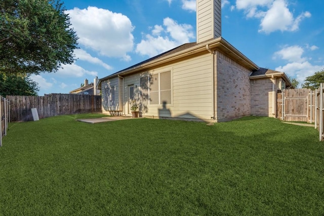back of property with a chimney, brick siding, and a patio area