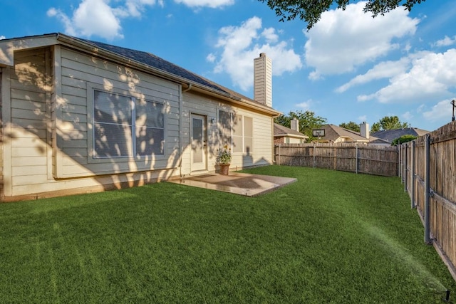 rear view of property featuring a chimney and a patio area