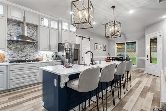 2230 Rana Park, Flint, TX 75762 - kitchen featuring wall chimney exhaust hood, gas cooktop, stainless steel fridge with ice dispenser, light wood-style floors, and recessed lighting