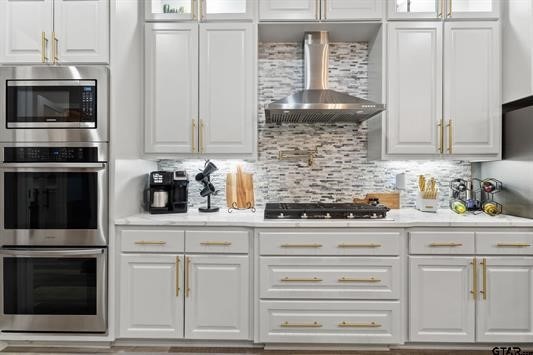 2230 Rana Park, Flint, TX 75762 - kitchen featuring wall chimney exhaust hood, white cabinetry, stainless steel appliances, and light countertops