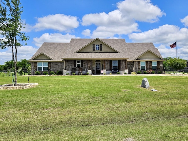craftsman house featuring a shingled roof, brick siding, and covered porch