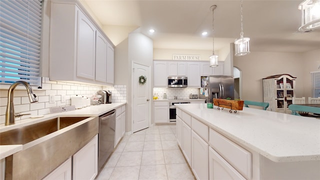 kitchen featuring appliances with stainless steel finishes, a sink, backsplash, white cabinetry, and recessed lighting