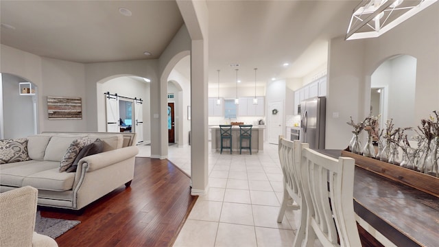 living room featuring a barn door, recessed lighting, and light tile patterned flooring