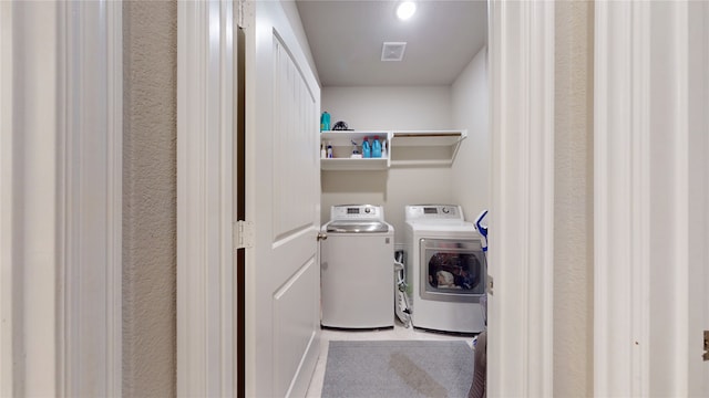 clothes washing area featuring separate washer and dryer and tile patterned floors