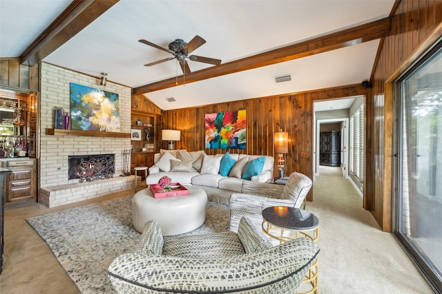 living room with wooden walls, light colored carpet, a ceiling fan, and a fireplace