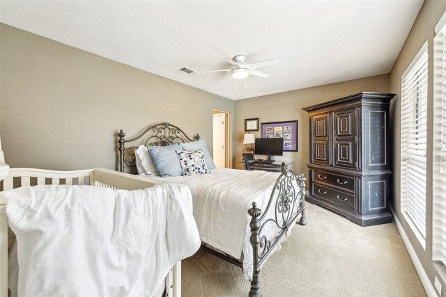 bedroom with light colored carpet and a ceiling fan