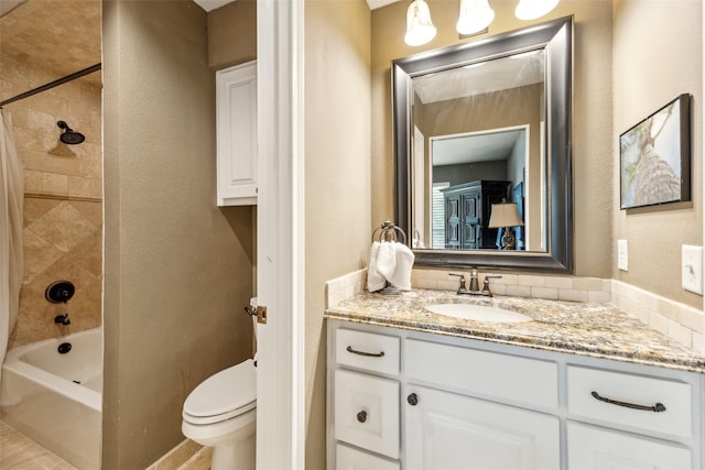 full bathroom with vanity, toilet, shower / tub combo, and a textured wall