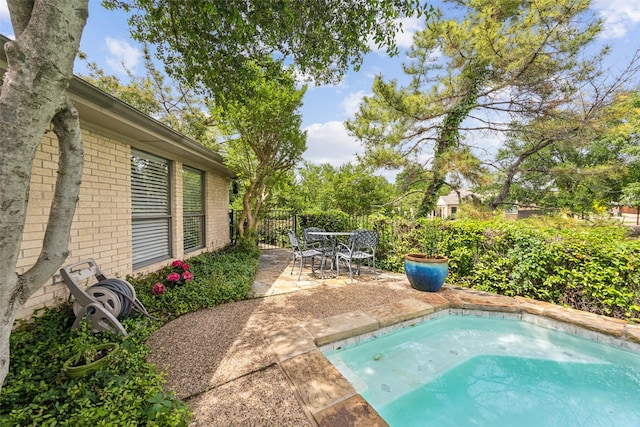 view of swimming pool with a patio, fence, and outdoor dining area
