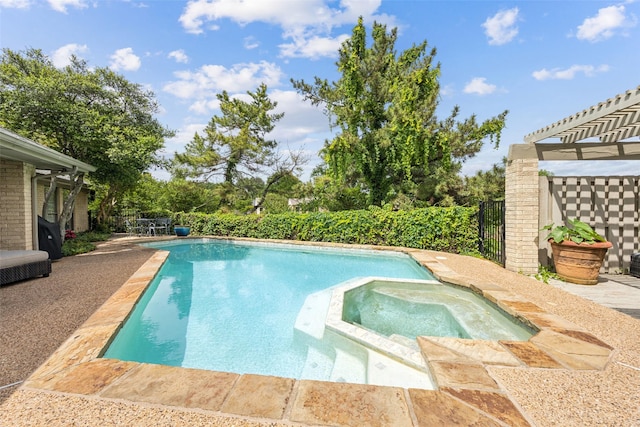 view of swimming pool with a pool with connected hot tub and fence