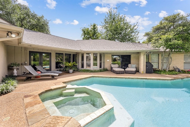view of pool featuring a pool with connected hot tub and a patio